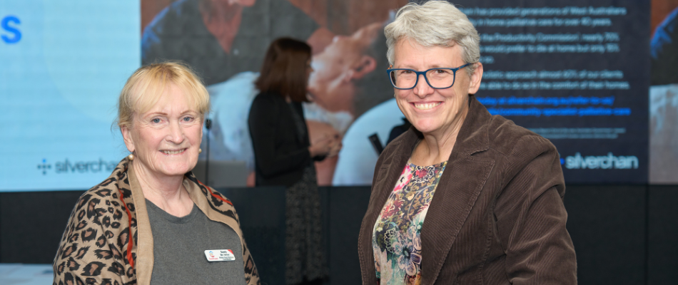 Two ladies smile at the camera